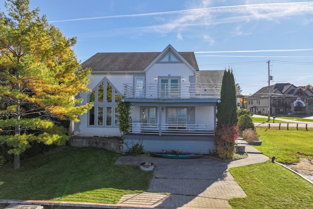 view of front facade featuring a front yard and a balcony