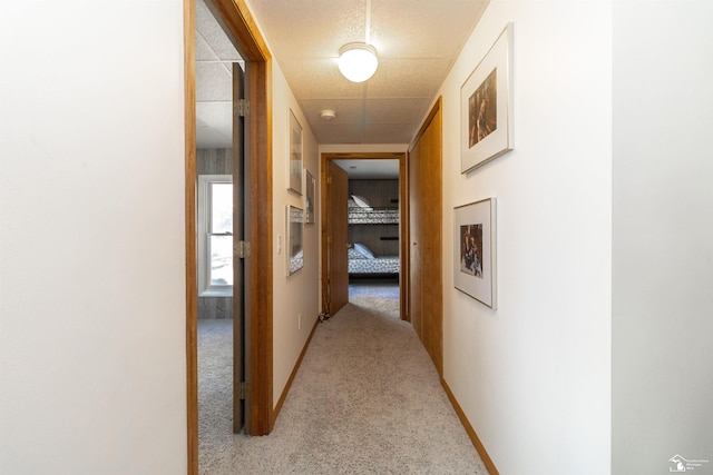 hall with light colored carpet