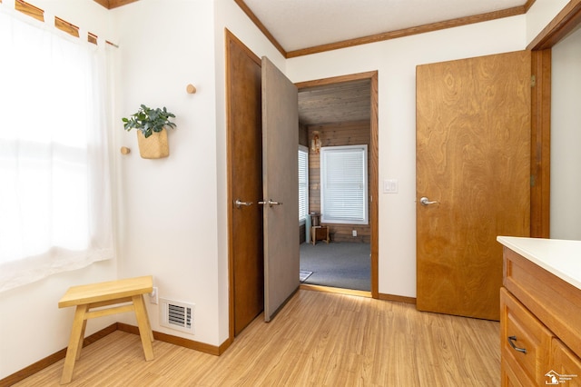 bathroom featuring hardwood / wood-style floors, vanity, ornamental molding, and a wealth of natural light