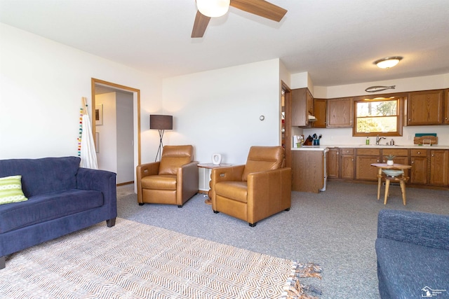 carpeted living room with ceiling fan and sink