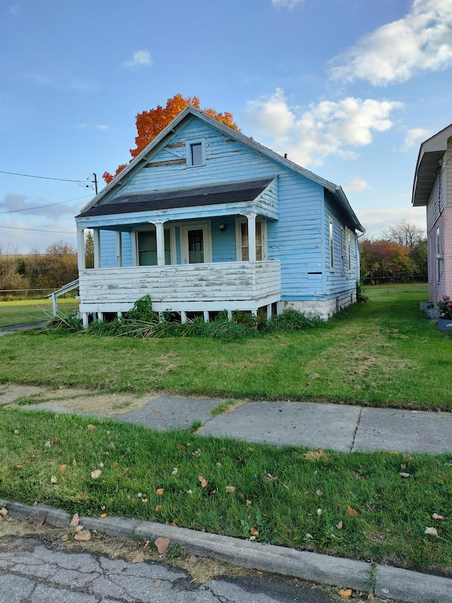 bungalow-style home with covered porch and a front yard