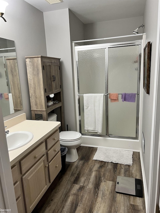 bathroom with a shower with door, wood-type flooring, and vanity