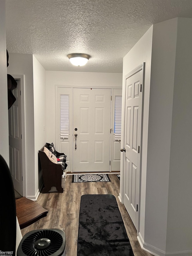 entryway with dark hardwood / wood-style floors and a textured ceiling