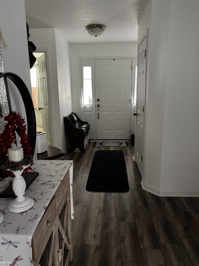 foyer with dark hardwood / wood-style floors and a textured ceiling