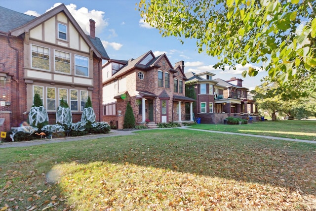 tudor home with a front lawn