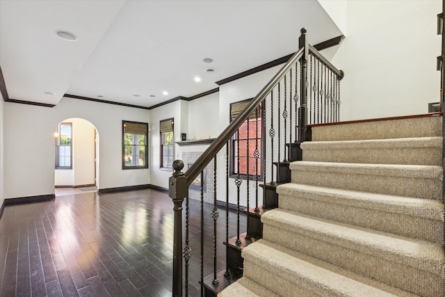 stairway with hardwood / wood-style floors and ornamental molding