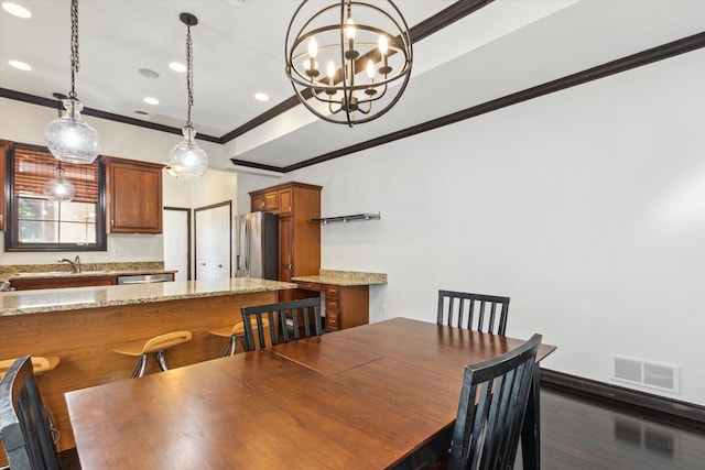 dining space with sink, a notable chandelier, crown molding, and dark wood-type flooring