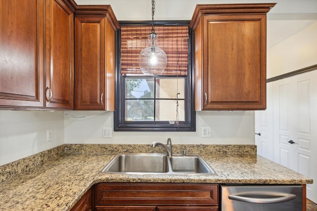 kitchen featuring dishwasher, decorative light fixtures, light stone counters, and sink