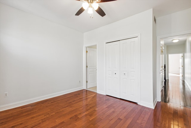 unfurnished bedroom featuring ceiling fan, dark hardwood / wood-style flooring, and a closet