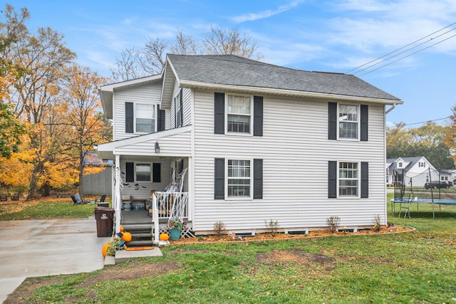 view of front of home featuring a front yard, a patio, a trampoline, and a wooden deck