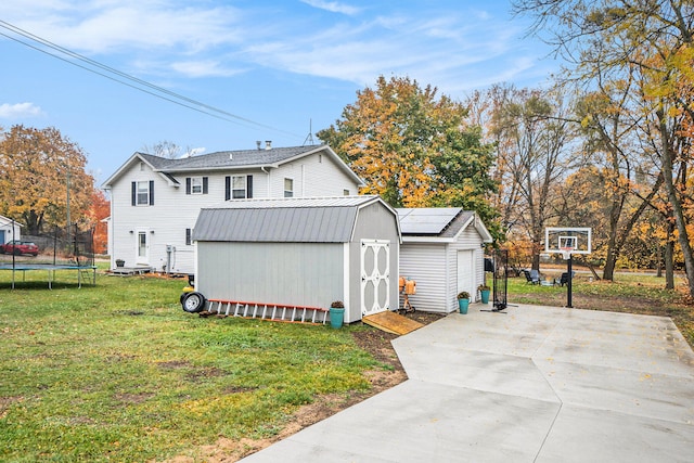 view of property exterior with a lawn, a storage unit, and a trampoline