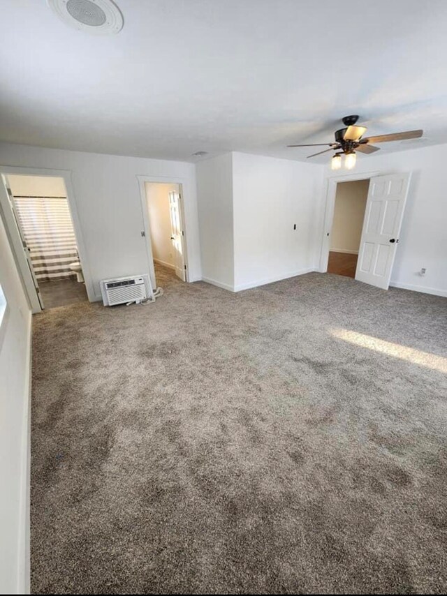 carpeted spare room featuring a wall mounted air conditioner and ceiling fan