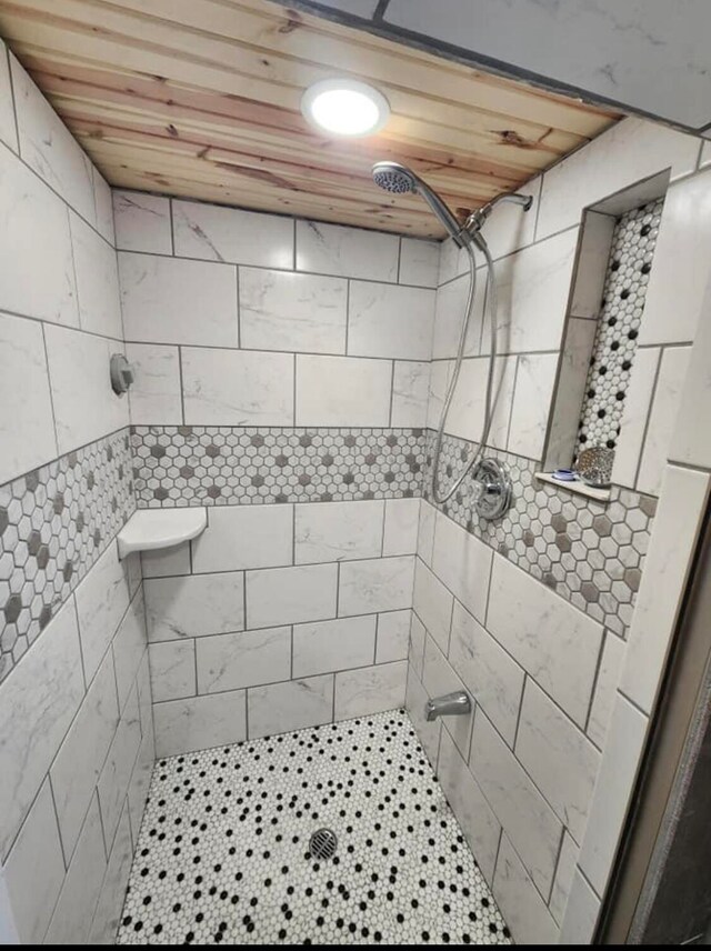 bathroom with wooden ceiling and tiled shower