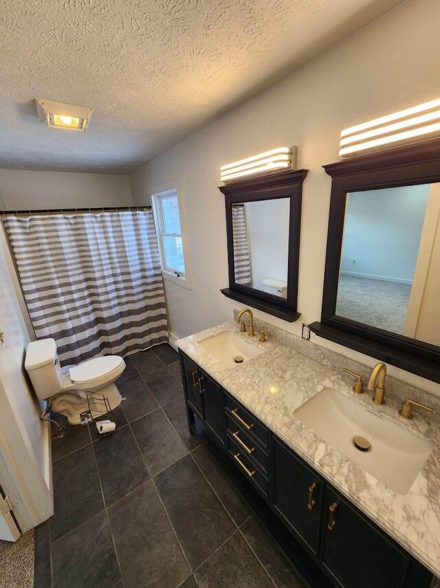 bathroom with vanity, toilet, and a textured ceiling