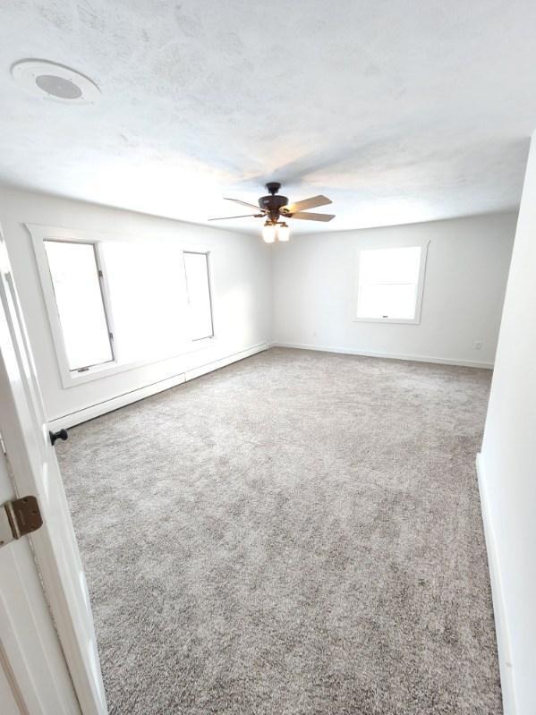 carpeted empty room featuring ceiling fan