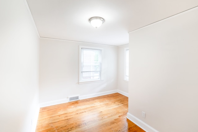 unfurnished room featuring crown molding and hardwood / wood-style flooring