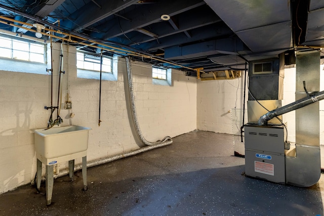 basement featuring heating unit and sink