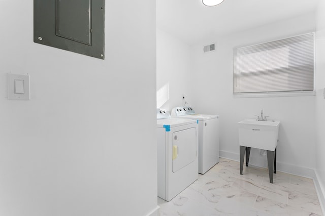 clothes washing area with washing machine and dryer and electric panel