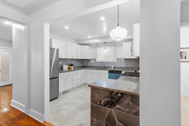 kitchen featuring white cabinets, decorative light fixtures, stainless steel appliances, and sink