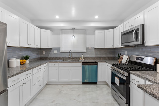 kitchen with white cabinets, dark stone countertops, sink, and appliances with stainless steel finishes