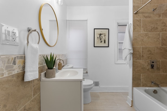 full bathroom featuring tile patterned floors, vanity, tiled shower / bath combo, and toilet