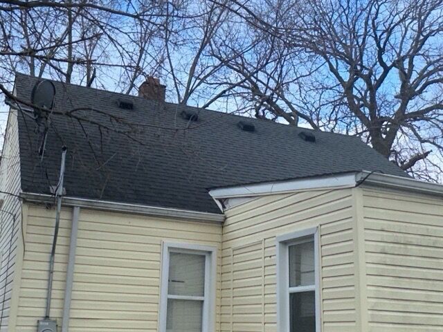 20264 Waltham St, Detroit, MI 48205 - exterior view of roof with shingles, a chimney, a downspout, gutters, and electric meter