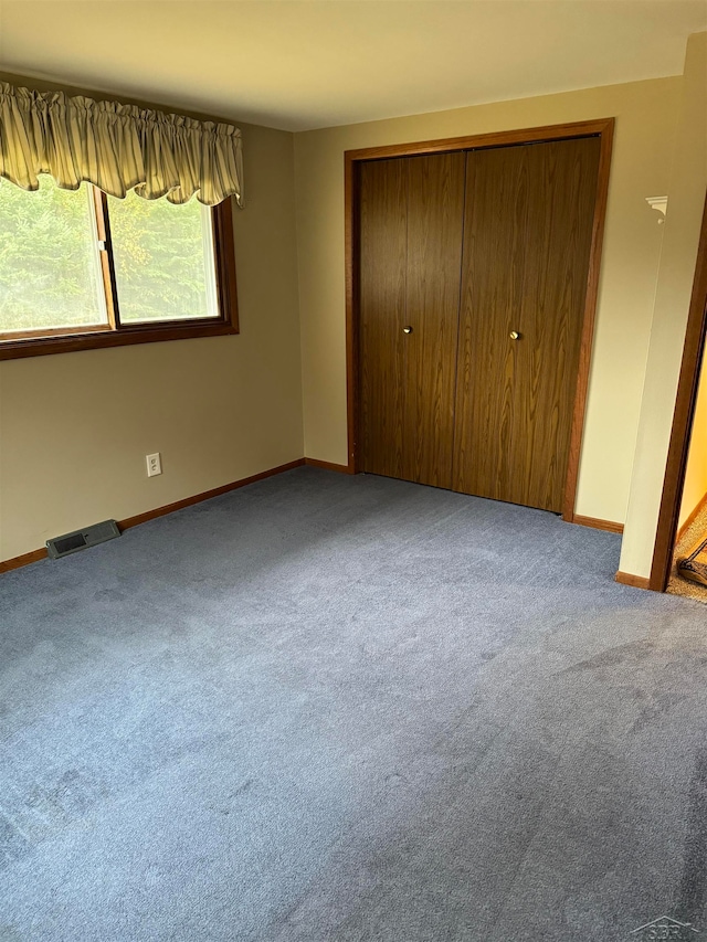 unfurnished bedroom with carpet floors and a closet