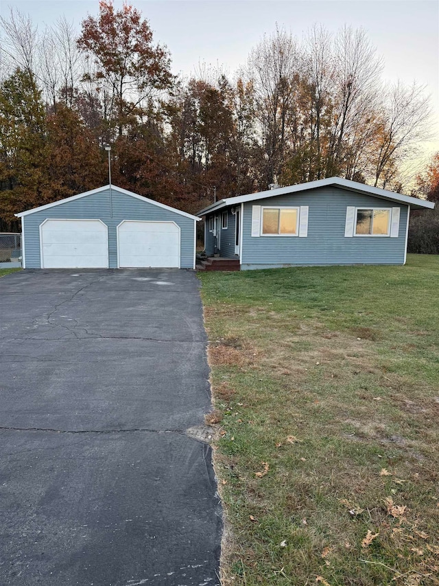 view of front of property featuring an outbuilding, a garage, and a front lawn