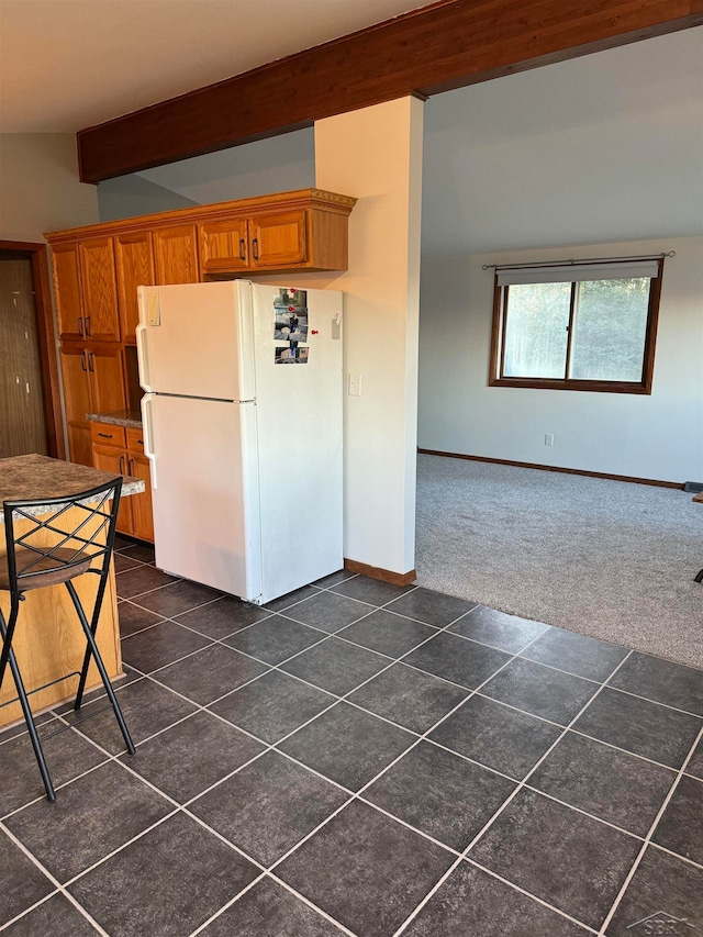 kitchen featuring vaulted ceiling with beams, white fridge, and dark carpet