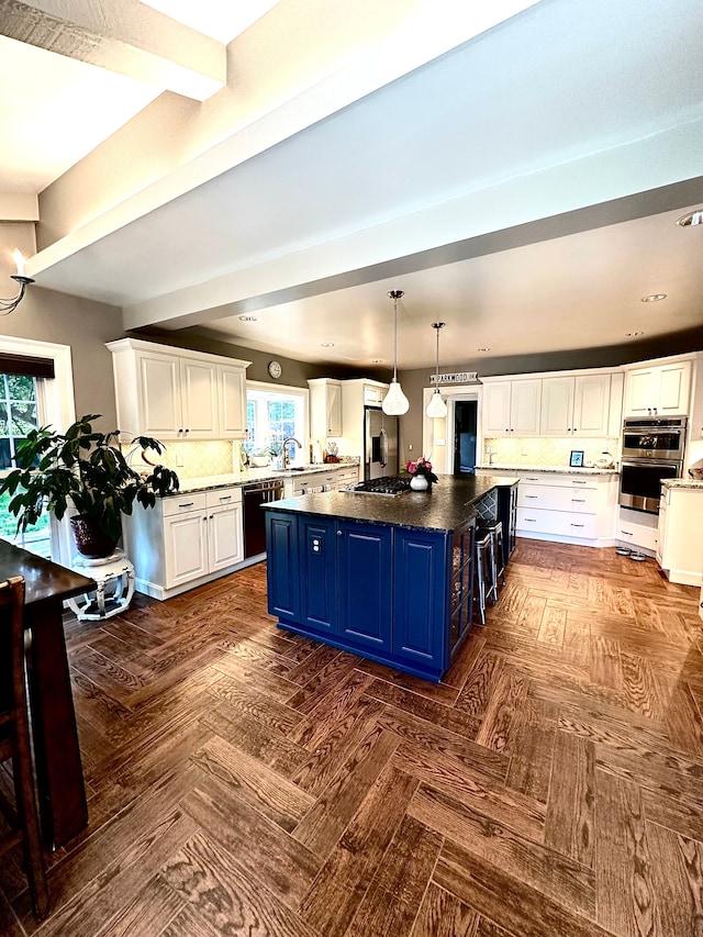 kitchen featuring blue cabinetry, appliances with stainless steel finishes, plenty of natural light, and a large island