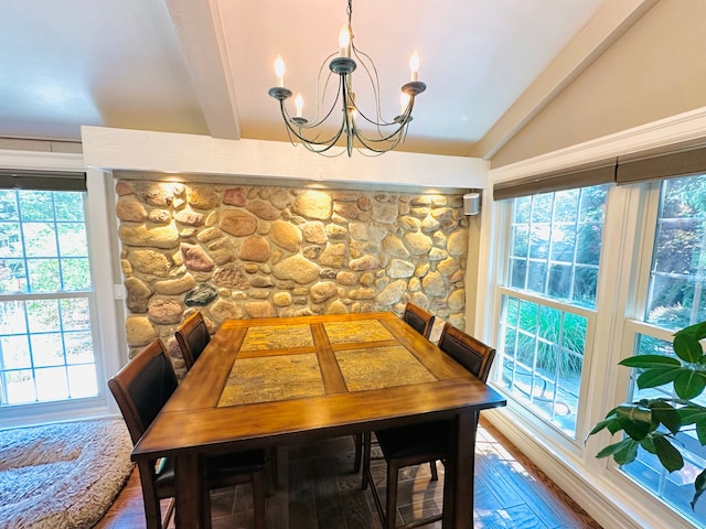 dining room with hardwood / wood-style floors, lofted ceiling with beams, a healthy amount of sunlight, and a notable chandelier