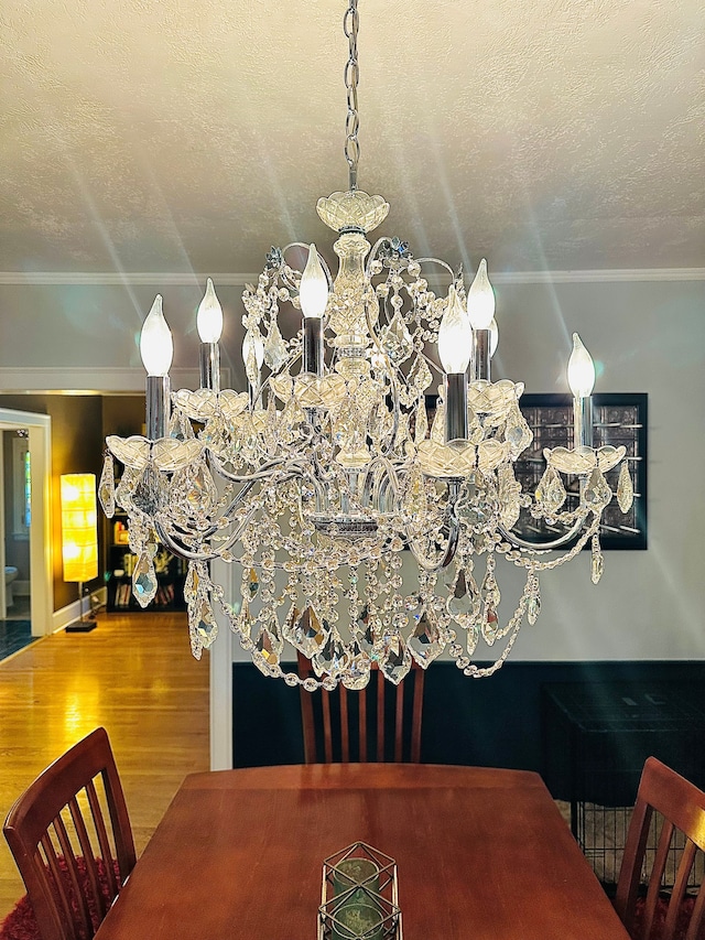 dining room with ornamental molding, a textured ceiling, and hardwood / wood-style flooring