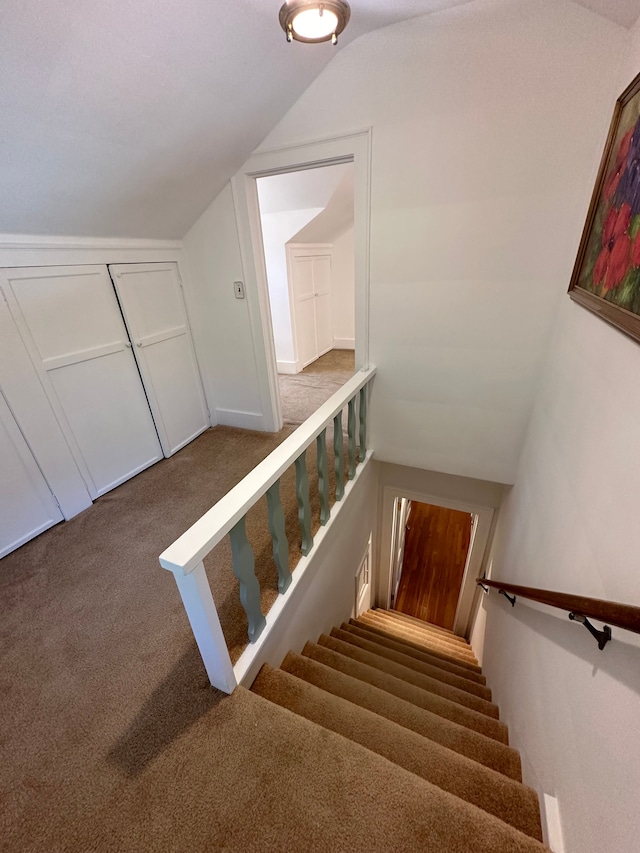 stairs featuring carpet floors and lofted ceiling