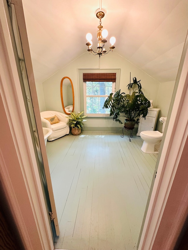 hallway featuring a notable chandelier, wood-type flooring, and vaulted ceiling