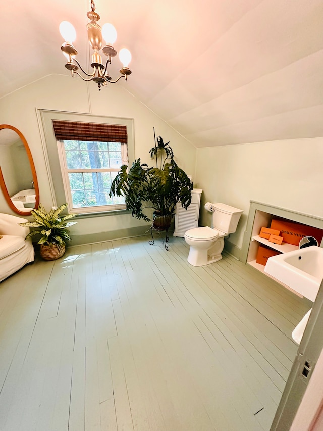 bathroom with hardwood / wood-style floors, a notable chandelier, and vaulted ceiling