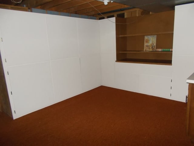 basement featuring dark colored carpet