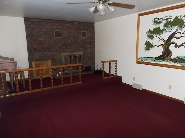 carpeted living room featuring a fireplace and ceiling fan