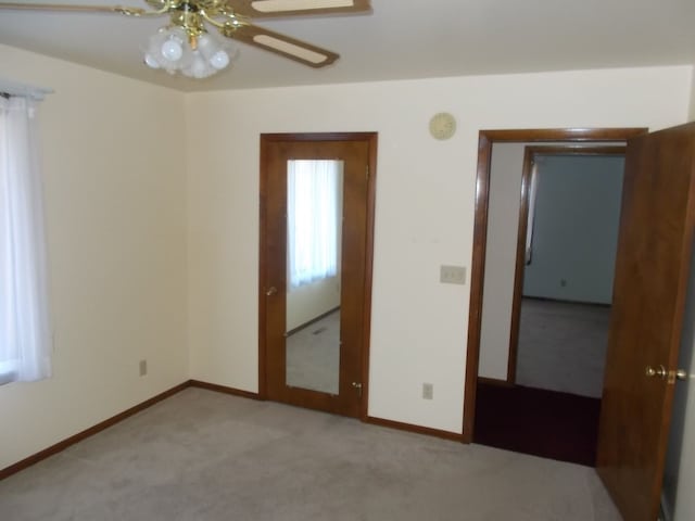 unfurnished bedroom featuring ceiling fan and light colored carpet