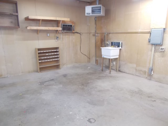 basement with sink, electric panel, and an AC wall unit