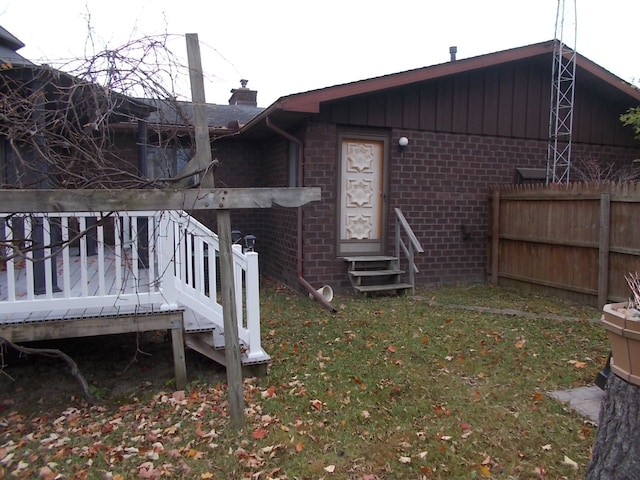 exterior space featuring a wooden deck and a lawn