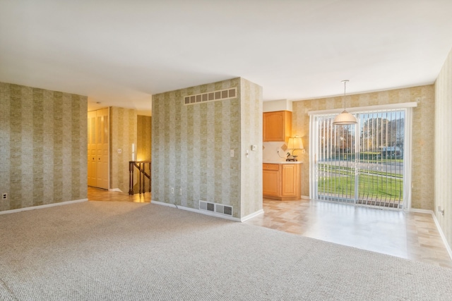 unfurnished living room with light colored carpet