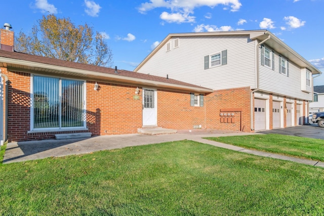 rear view of property featuring a yard and a garage