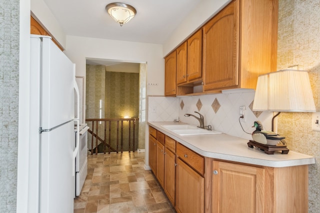 kitchen with tasteful backsplash, white appliances, and sink