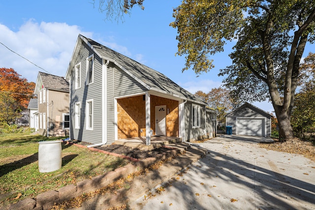 view of front of property featuring a garage, a front lawn, and an outdoor structure