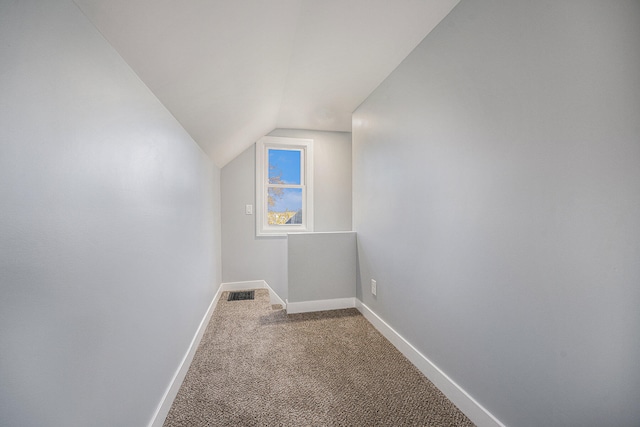 additional living space with carpet flooring and lofted ceiling