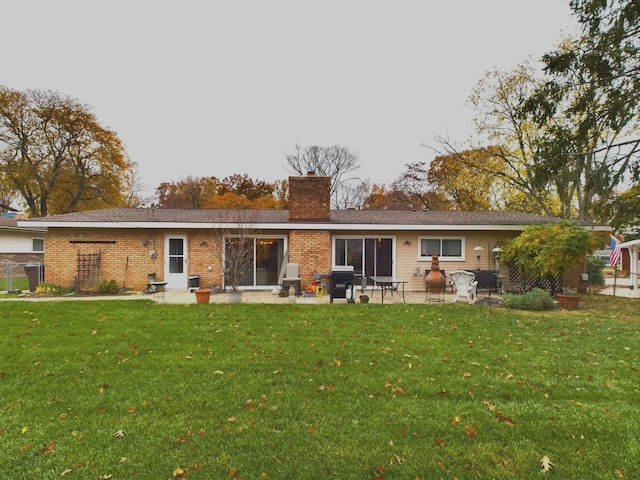 back of property with a yard and a patio area