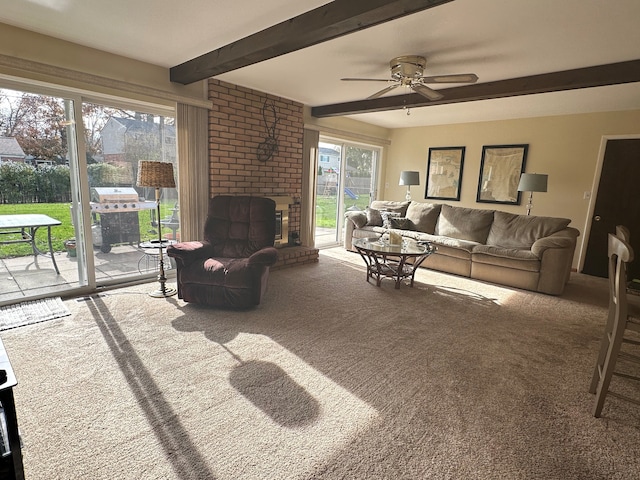 carpeted living room with beam ceiling, a brick fireplace, and ceiling fan