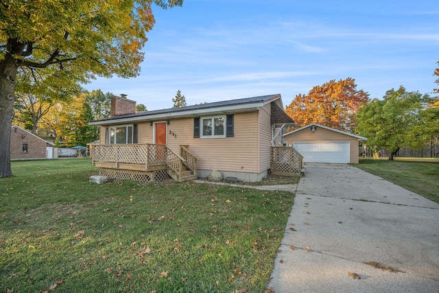 view of front of home featuring a front yard, a garage, and an outdoor structure