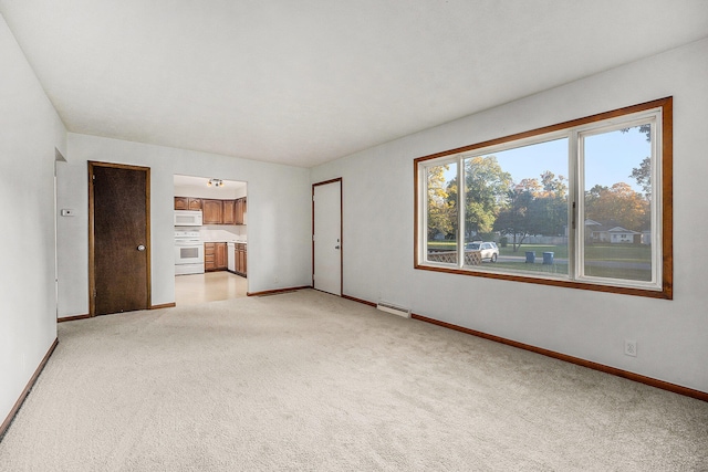 unfurnished living room with light carpet and a baseboard radiator