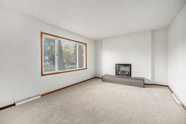 unfurnished living room featuring baseboard heating, a fireplace, and carpet flooring